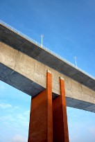 Concrete bridge on red brick pile over blue sky
